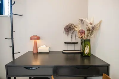 a black desk with a vase of flowers on it at Mi-Villa AZABU\u4e28Tokyo Tower View in Tokyo