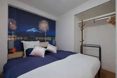 a bedroom with a large bed with a painting on the wall at Ardel-hohu luxuryroom-1st floor-3 Bedroom-3shower,110square in Tokyo