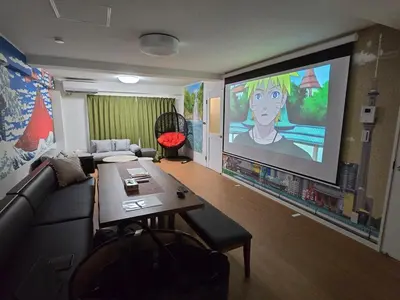 a living room with a couch and a large screen at Ardel-hohu luxuryroom-1st floor-3 Bedroom-3shower,110square in Tokyo