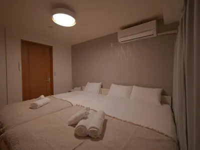 a bedroom with a large white bed with towels on it at Kiryo Tokyo Kami Itabashi 2 Bedroom Apartment with Kitchen near Ikebukuro in Tokyo