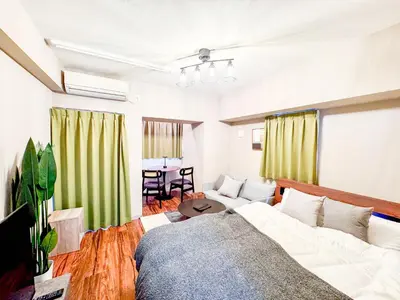 a bedroom with a bed and a couch and a table at Asakusa Kototoibashi Facing Tokyo Skytree in Tokyo