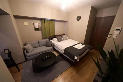 a small bedroom with a bed and a couch at Asakusa Kototoibashi Facing Tokyo Skytree in Tokyo
