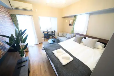 a bedroom with a bed and a couch in a room at Asakusa Kototoibashi Facing Tokyo Skytree in Tokyo