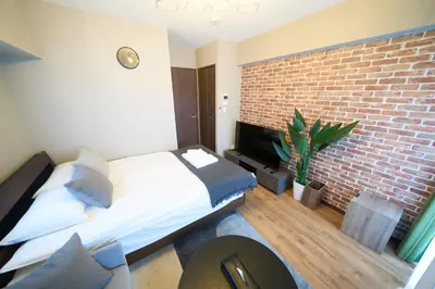 a bedroom with a bed and a brick wall at Asakusa Kototoibashi Facing Tokyo Skytree in Tokyo