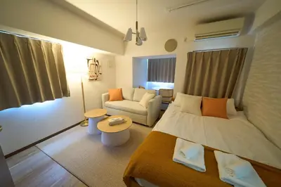 a small bedroom with a bed and a couch at Triphome Kototoibashi Facing Tokyo Skytree in Tokyo
