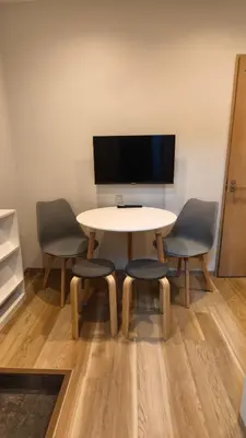 a table with three chairs and a tv on the wall at Makino Building - Vacation STAY 16039v in Tokyo