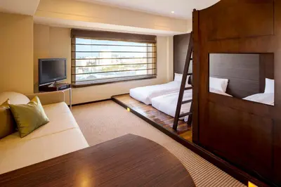 a hotel room with a bunk bed and a couch at Urayasu Brighton Hotel Tokyo Bay in Urayasu