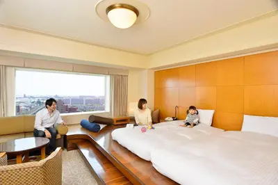 a family sitting in a bedroom with a large bed at Urayasu Brighton Hotel Tokyo Bay in Urayasu