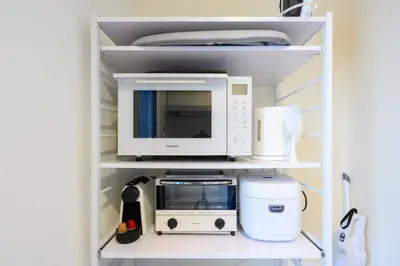 a microwave and other appliances on a shelf at IKEPOND HOUSE Tokyo in Tokyo
