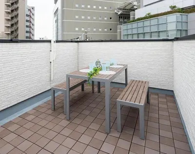 a table and bench sitting on a rooftop patio at IKEPOND HOUSE Tokyo in Tokyo