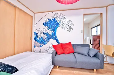 a bedroom with a couch and a painting of a wave at BMO102A Direct bus to Disney from next station Max5 in Tokyo