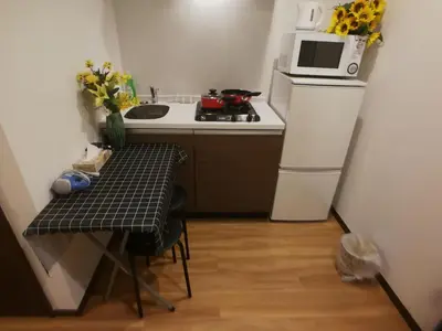 a small kitchen with a small table and a microwave at \u611b\u306e\u5c4b\u30db\u30c6\u30eb\u6c60\u888b in Tokyo