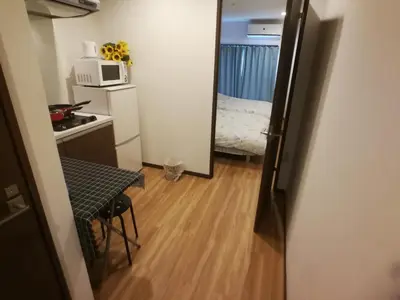 a small room with a kitchen and a microwave at \u611b\u306e\u5c4b\u30db\u30c6\u30eb\u6c60\u888b in Tokyo