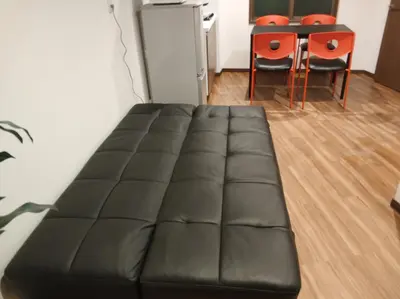 a black leather couch in a living room with a table at \u611b\u306e\u5c4b\u30db\u30c6\u30eb\u6c60\u888b in Tokyo