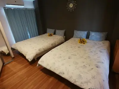 two beds in a bedroom with flowers on them at \u611b\u306e\u5c4b\u30db\u30c6\u30eb\u6c60\u888b in Tokyo