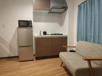 a living room with a couch and a kitchen at \u611b\u306e\u5c4b\u30db\u30c6\u30eb\u6c60\u888b in Tokyo