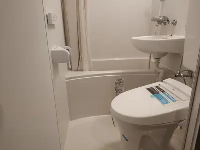 a white bathroom with a toilet and a sink at \u611b\u306e\u5c4b\u30db\u30c6\u30eb\u6c60\u888b in Tokyo