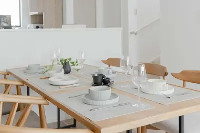 a dining room table with white dishes and wine glasses at \u56db\u5b63\u306e\u5bbf \u65b0\u7bc9\u4e00\u8ed2\u5bb6\u8cb8\u5207 \u65d7\u30f6\u8c37\u99c5\u5f92\u6b699\u5206 \u65b0\u5bbf4\u5206 \u9759\u304b\u3067\u4fbf\u5229\u306a\u4f4f\u5b85\u8857 \u6700\u59276\u540d in Tokyo