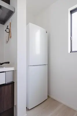a white refrigerator in a kitchen next to a window at \u56db\u5b63\u306e\u5bbf \u65b0\u7bc9\u4e00\u8ed2\u5bb6\u8cb8\u5207 \u65d7\u30f6\u8c37\u99c5\u5f92\u6b699\u5206 \u65b0\u5bbf4\u5206 \u9759\u304b\u3067\u4fbf\u5229\u306a\u4f4f\u5b85\u8857 \u6700\u59276\u540d in Tokyo