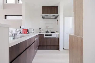 a kitchen with wooden cabinets and a white refrigerator at \u56db\u5b63\u306e\u5bbf \u65b0\u7bc9\u4e00\u8ed2\u5bb6\u8cb8\u5207 \u65d7\u30f6\u8c37\u99c5\u5f92\u6b699\u5206 \u65b0\u5bbf4\u5206 \u9759\u304b\u3067\u4fbf\u5229\u306a\u4f4f\u5b85\u8857 \u6700\u59276\u540d in Tokyo