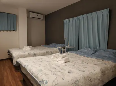 two beds with towels on them in a bedroom at \u611b\u306e\u5c4b\u6c11\u6cca\u6c60\u888b in Tokyo