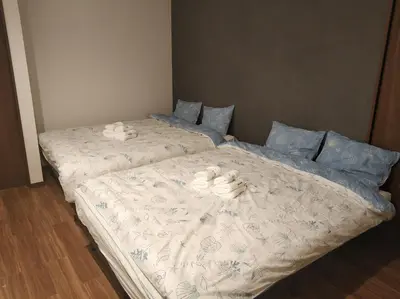 two beds in a bedroom with towels on them at \u611b\u306e\u5c4b\u6c11\u6cca\u6c60\u888b in Tokyo