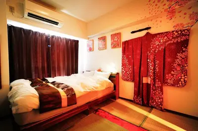 a bedroom with a bed and a window with red curtains at 1 stop from Shinjuku, 3 minutes, Japanese-style room, with balcony, Japanese modern in Tokyo