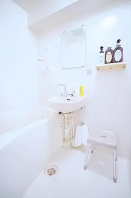 a white bathroom with a sink and a bath tub at 1 stop from Shinjuku, 3 minutes, Japanese-style room, with balcony, Japanese modern in Tokyo