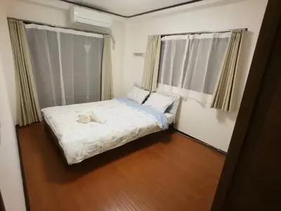 a small bedroom with a bed and two windows at \u611b\u306e\u5c4b\u30db\u30c6\u30eb\u58a8\u7530 in Tokyo