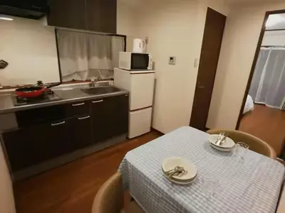 a kitchen with a table and a kitchen with a sink and a table and chairs at \u611b\u306e\u5c4b\u30db\u30c6\u30eb\u58a8\u7530 in Tokyo