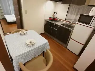 a small kitchen with a table and a white table cloth at \u611b\u306e\u5c4b\u30db\u30c6\u30eb\u58a8\u7530 in Tokyo