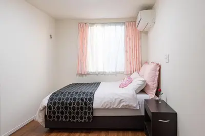 a small bedroom with a bed and a window at Omorikita 4chome House in Tokyo