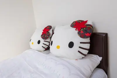 two hello kitty pillows sitting on a bed at Omorikita 4chome House in Tokyo