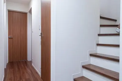 a hallway with stairs leading to a door at Omorikita 4chome House in Tokyo