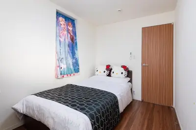a bedroom with a large bed and a window at Omorikita 4chome House in Tokyo