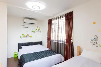 a bedroom with two beds and a window at Omorikita 4chome House in Tokyo