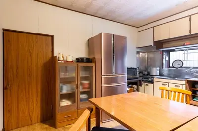 a kitchen with a wooden table and a refrigerator at comin in Tokyo