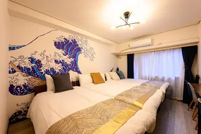 two beds in a room with a mural of a wave at 6min Shibuya Station 4 Max A165 in Tokyo