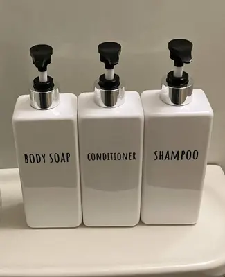 three white soap bottles sitting on top of a sink at 6min Shibuya Station 4 Max A165 in Tokyo