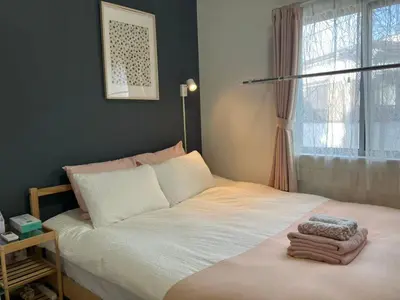 a bedroom with a large bed with a window at 202 Yamanote Line Near Ueno Newly Built Cozy Apartment in Tokyo