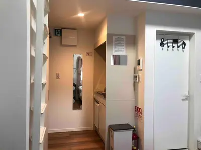 a room with a kitchen with a refrigerator and a door at 202 Yamanote Line Near Ueno Newly Built Cozy Apartment in Tokyo