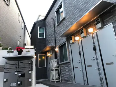 a garage with a large door and a building at 202 Yamanote Line Near Ueno Newly Built Cozy Apartment in Tokyo