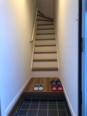 two pairs of shoes are sitting under a staircase at 203 Yamanote Line Near Ueno Park Cozy New Apartment in Tokyo