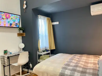 a bedroom with a bed and a desk and a tv at 203 Yamanote Line Near Ueno Park Cozy New Apartment in Tokyo