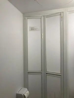 a bathroom with two glass doors and a toilet at 203 Yamanote Line Near Ueno Park Cozy New Apartment in Tokyo