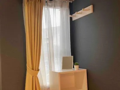 a window with a yellow curtain and a computer on a table at 203 Yamanote Line Near Ueno Park Cozy New Apartment in Tokyo