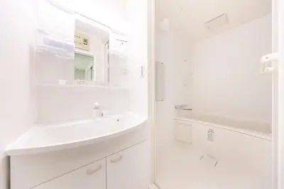 a white bathroom with a sink and a mirror at Sunny Home Asakusa in Tokyo
