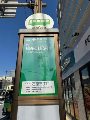 a sign for a bus stop in front of a building at Sunny Home Asakusa in Tokyo