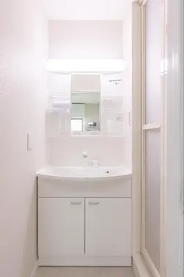 a white bathroom with a sink and a mirror at Sunny Home Asakusa in Tokyo