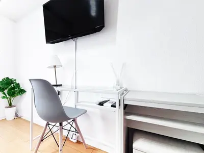 a desk with a chair and a tv on a wall at \u65b0\u5bbf\u6b4c\u821e\u4f0e\u753a\u3059\u3050\u306e\u30ca\u30a4\u30c8\u30e9\u30a4\u30d5\u306b\u6700\u9069\u306aWi-Fi\u5b8c\u5099\u8cb8\u5207\u30a2\u30d1\u30fc\u30c8 in Tokyo